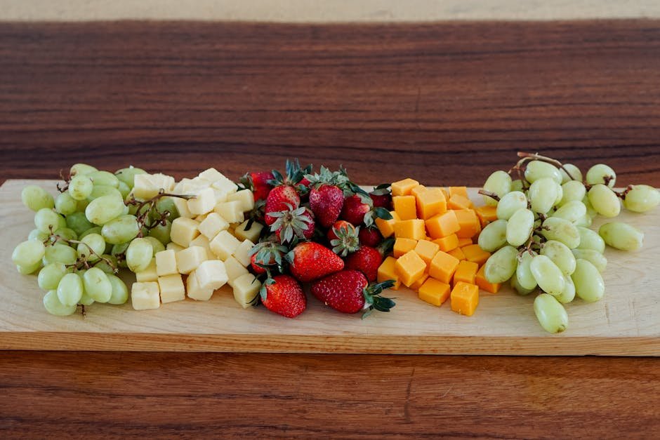 Assortiment de fromages avec des fruits frais sur une planche en bois
