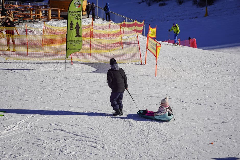 Parent tirant un enfant en luge sur les pistes enneigees