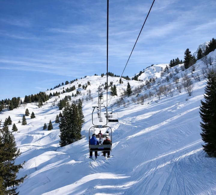 Skieurs sur telesiege montant les pentes enneigees